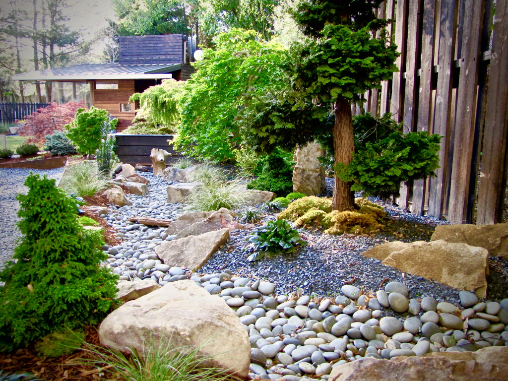 Zen-inspired landscaping with Japanese trees and rock garden.
